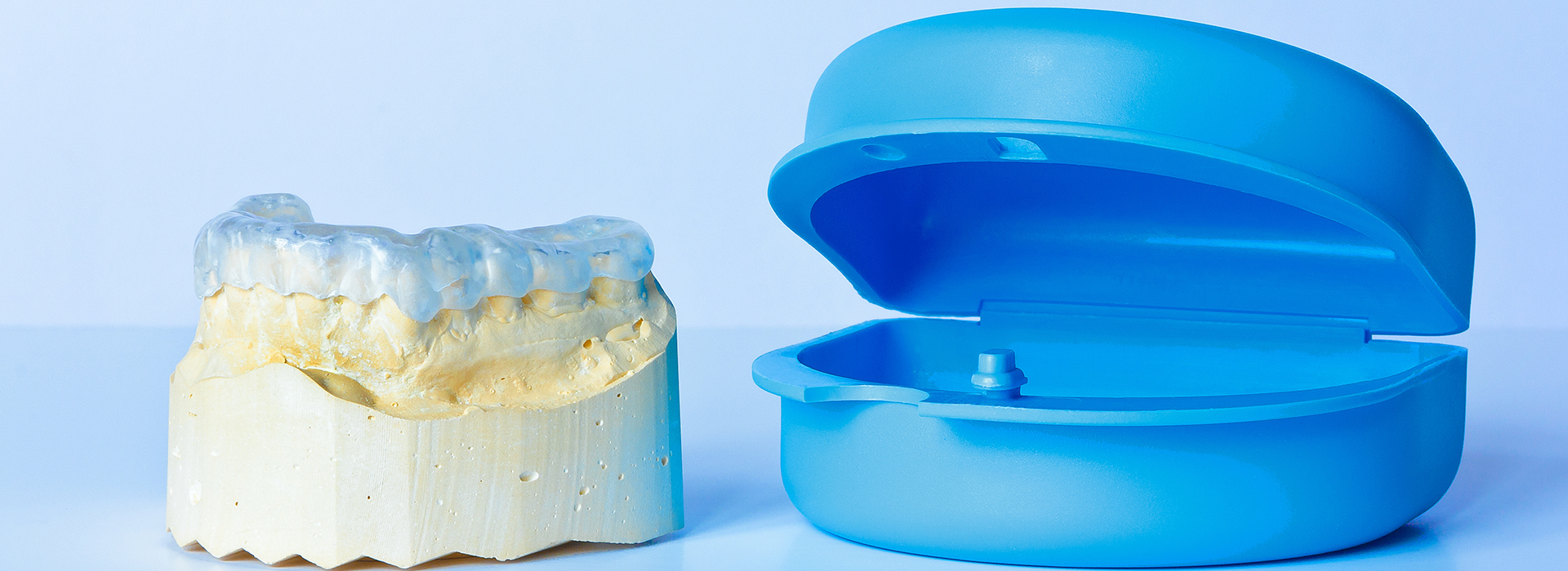 An image displaying two dental implant models  one with a blue cap and another with a yellow cap.